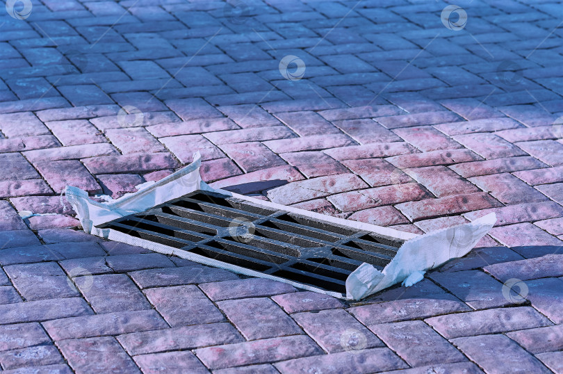 Скачать Железные решетки для ливневой канализации, выложенные тротуарной плиткой. Осенью яму закрывают полиэтиленовым пакетом, чтобы предотвратить засорение подземных коммуникаций. фотосток Ozero