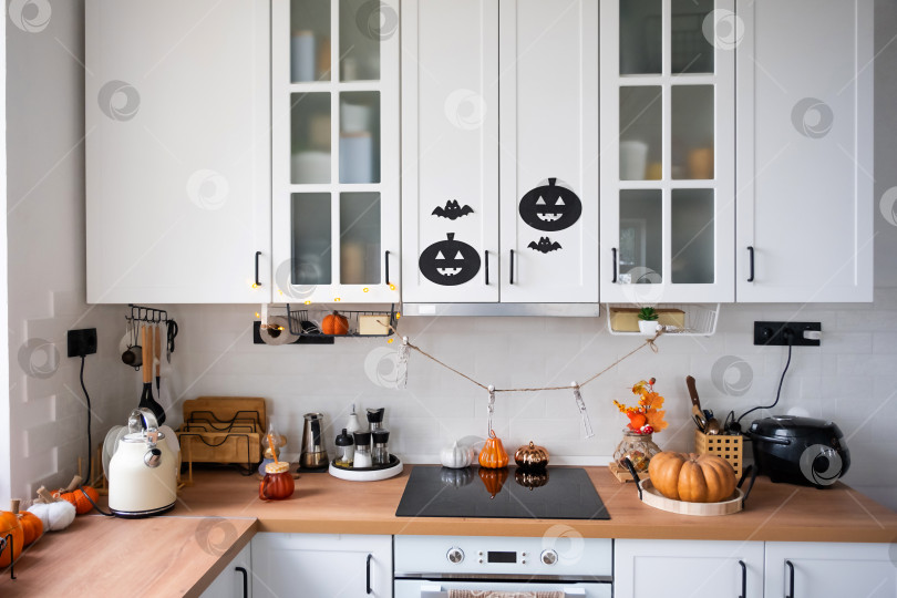 Скачать Интерьер белой кухни в стиле Сканди украшен тыквами на Хэллоуин. Осеннее настроение, домашний декор к празднику фотосток Ozero