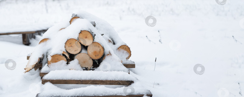 Скачать Штабель бревен для растопки лежит под снегом. Альтернативное экологичное отопление зимой фотосток Ozero