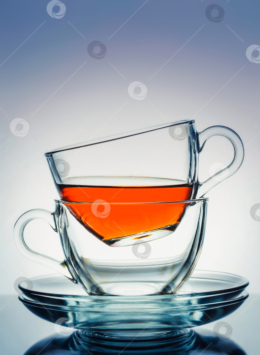 Скачать Две стеклянные прозрачные чашки с чаем и блюдцами на бело-голубом градиентном фоне. Перерыв на чай.Утреннее чаепитие. фотосток Ozero