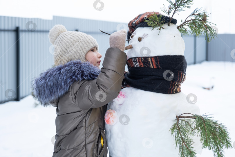 Бабушка лепит снеговика