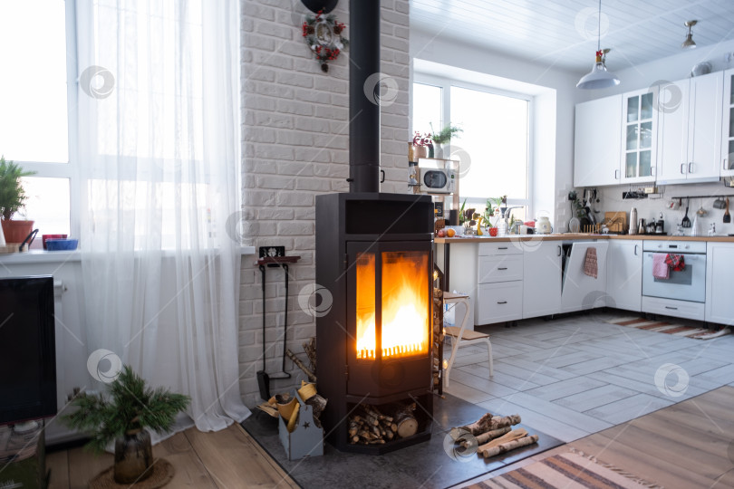 Скачать Черная печь, камин в интерьере дома в стиле лофт. Альтернативное экологичное отопление, теплая уютная комната дома, сжигание дров фотосток Ozero