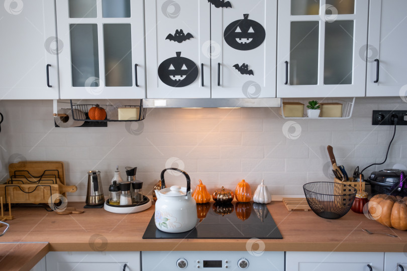 Скачать Интерьер белой кухни в стиле Сканди украшен тыквами на Хэллоуин. Осеннее настроение, домашний декор к празднику фотосток Ozero