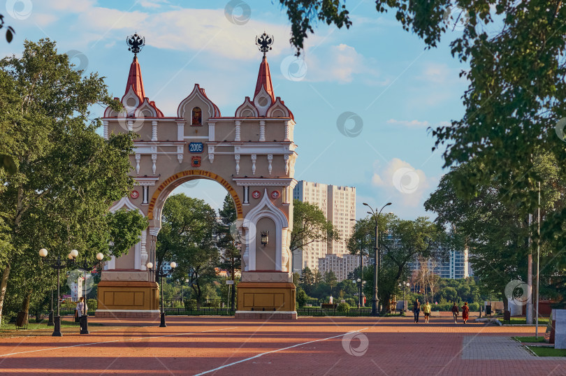 Скачать Triumphal arch in the evening during sunset.  Monument on the border of the Russian Federation. The sky with clouds and trees. фотосток Ozero