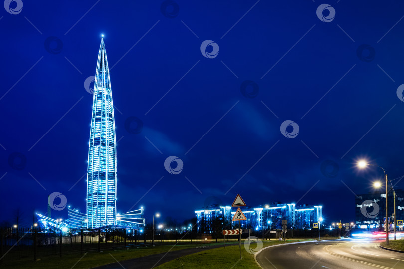 Скачать Башня Газпрома светится на ночной улице голубым светом фотосток Ozero