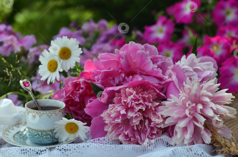 Скачать Beautiful still life with peony flowers on the table in the garden. Romantic greeting card for birthday, Valentines, Mothers Day concept. Summer background with vintage objects фотосток Ozero