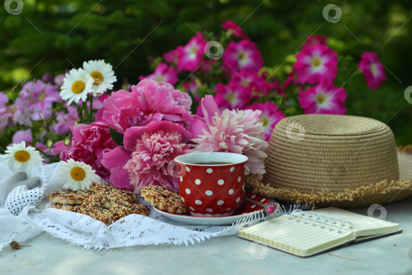 Скачать Beautiful still life with peony flowers, hat, cup and diary on the table. Romantic greeting card for birthday, Valentines, Mothers Day concept. фотосток Ozero