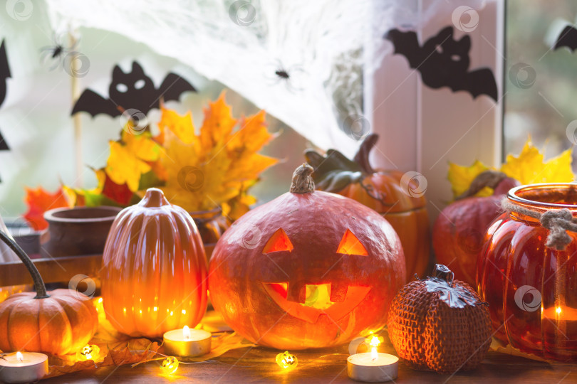 Скачать Праздничный декор дома на подоконнике на Хэллоуин - тыквы, фонарики Джек о, черепа, летучие мыши, паутина, пауки, свечи и гирлянда - уютное и жуткое настроение фотосток Ozero