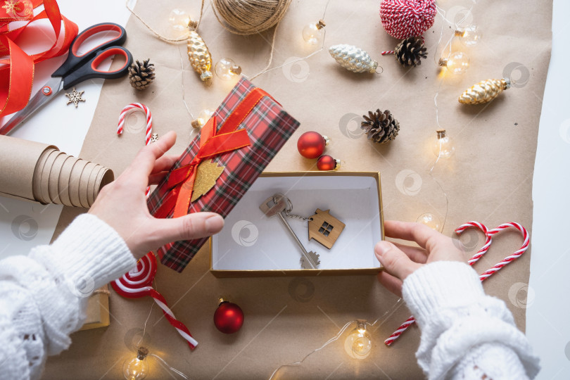 Скачать Ключ от дома с брелком на уютном доме в подарочной коробке с рождественским декором. Упакуйте подарок на Новый год, Рождество. Строительство, проект, переезд в новый дом, ипотека, аренда, покупка недвижимости фотосток Ozero