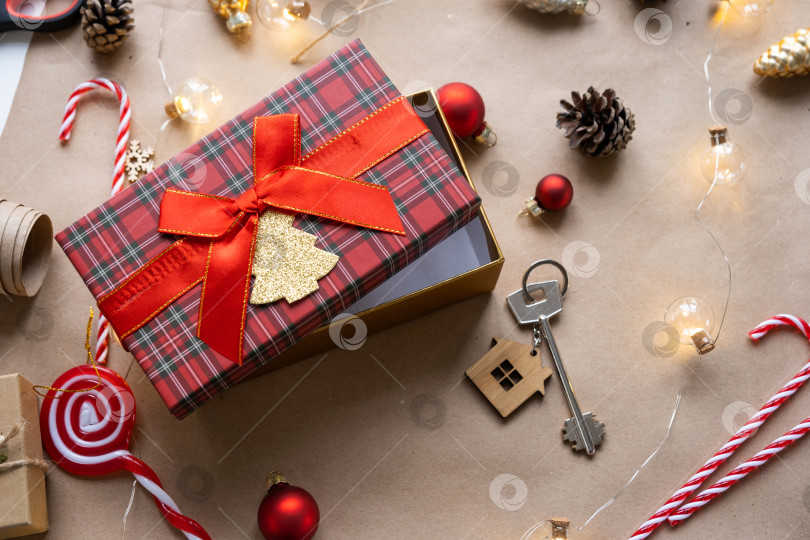 Скачать Ключ от дома с брелком для ключей на уютном доме в подарочной коробке с рождественским декором. Упакуйте подарок на Новый год, Рождество. Строительство, проект, переезд в новый дом, ипотека, аренда, покупка недвижимости фотосток Ozero