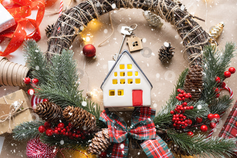 Скачать Ключ от дома с брелоком на уютном доме с рождественским декором макета. Подарок на Новый год, Рождество. Строительство, дизайн, проект, переезд в новый дом, ипотека, аренда и покупка недвижимости фотосток Ozero