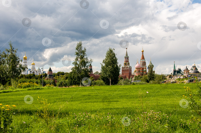 Скачать Москва, Россия - 21 июля 2023: Вид на собор Василия Блаженного и Спасскую башню Московского Кремля из парка Зарядье фотосток Ozero