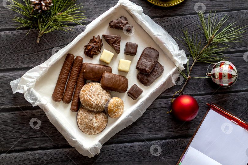 Скачать Рождественский декор, сладости на деревянном столе. чистый лист блокнота для составления плана на новый год в уютной обстановке фотосток Ozero