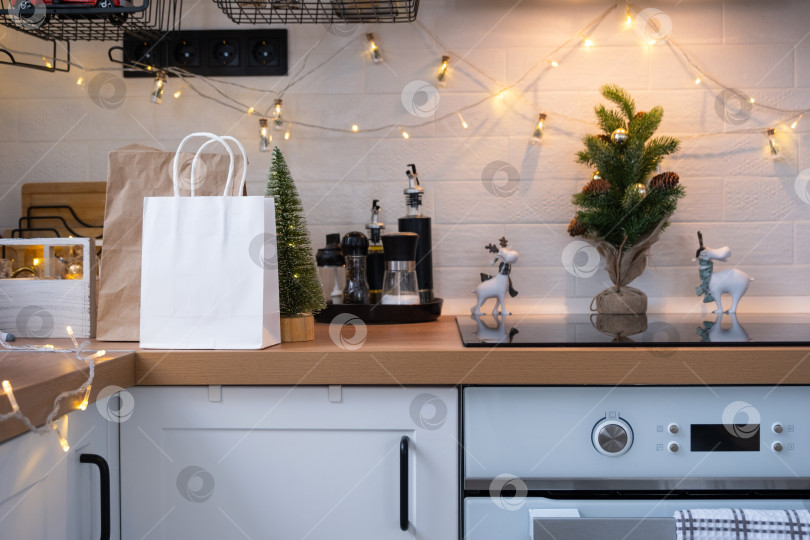 Скачать Контейнеры службы доставки еды на столе white scandi для праздничной кухни в рождественском декоре. Канун Нового года, экономия времени, лень готовить, заказ горячего, одноразовая пластиковая коробка в сказочном свете. макет фотосток Ozero