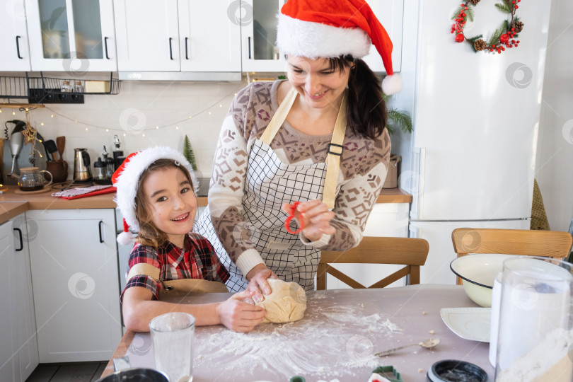 Скачать Мама и дочь на белой кухне готовят печенье к Рождеству и новому году. Семейный день, подготовка к празднику, учимся готовить вкусную выпечку, вырезаем формы из теста с помощью формочек фотосток Ozero