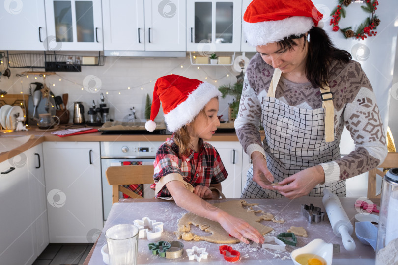 Скачать Мама и дочь на белой кухне готовят печенье к Рождеству и новому году. Семейный день, подготовка к празднику, учимся готовить вкусную выпечку, вырезаем формы из теста с помощью формочек фотосток Ozero