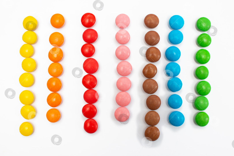 Скачать Разноцветные маленькие конфеты в виде драже, разложенные по цветовым линиям фотосток Ozero