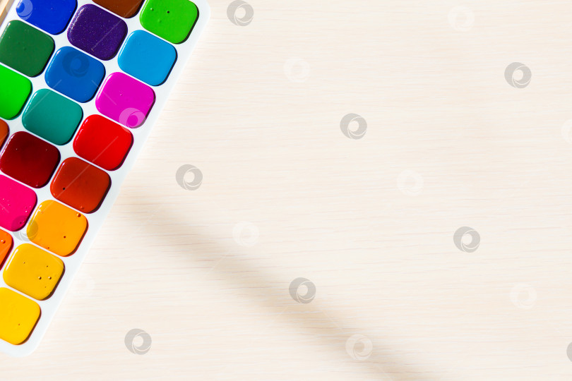 Скачать Разноцветные яркие акварельные краски на столе фотосток Ozero