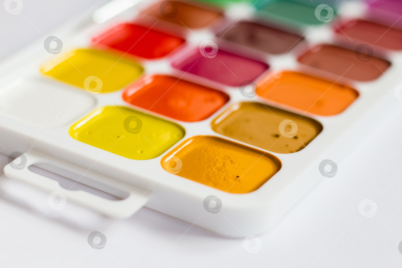 Скачать Разноцветные яркие акварельные краски на столе крупным планом фотосток Ozero