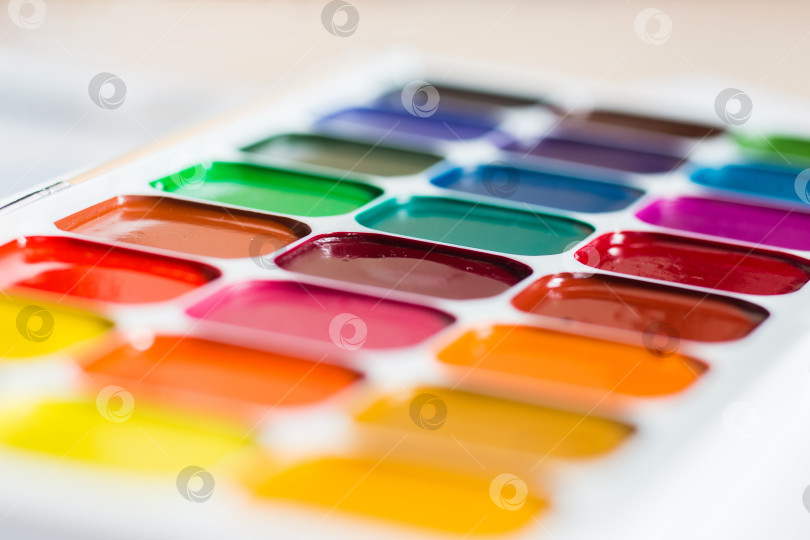 Скачать Разноцветные яркие акварельные краски на столе крупным планом фотосток Ozero