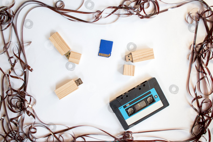 Скачать Старый картридж диктофона, флешка и компакт-диски лежат в рамке от перепутанной кассеты фотосток Ozero