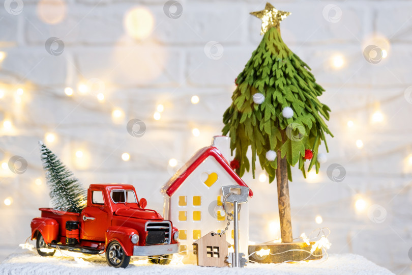 Скачать Ключ от дома с брелоком на уютном доме с рождественским декором. Подарок на Новый год, Рождество. Строительство, дизайн, проект, переезд в новый дом, ипотека, аренда и покупка недвижимости фотосток Ozero