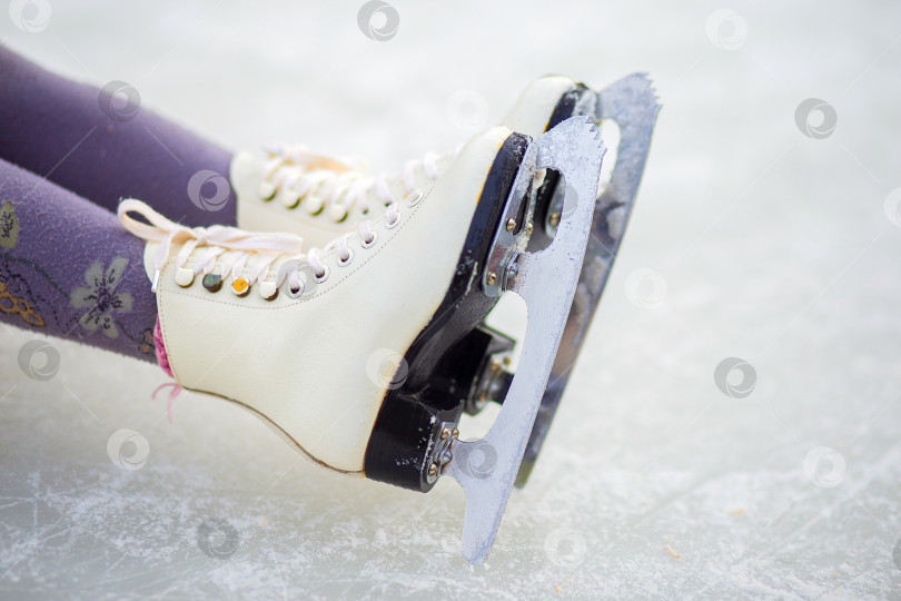 Скачать Детские фигурные коньки на ледовом катке крупным планом. Фигурное катание - зимний вид спорта фотосток Ozero