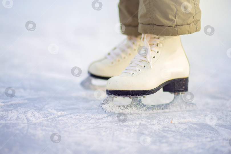 Скачать Ребенок в фигурных коньках стоит на льду, крупным планом катается на коньках. фотосток Ozero