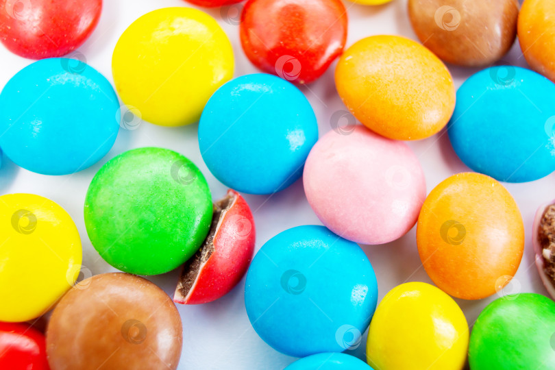 Скачать Множество разноцветных маленьких круглых леденцовых пилюль разбросано по столу, вид сверху фотосток Ozero