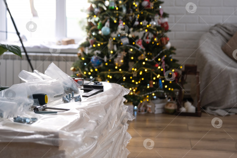 Скачать Строительные материалы с инструментами для ремонта дома на фоне рождественской елки - декоративный ремонт и строительство к новому году фотосток Ozero