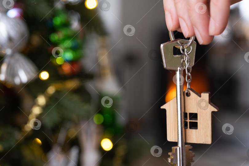 Скачать Ключ от дома с брелоком висит на рождественской елке. Подарок на Новый год, Рождество. Строительство, дизайн, проект, переезд в новый дом, ипотека, аренда и покупка недвижимости. Пространство для копирования фотосток Ozero