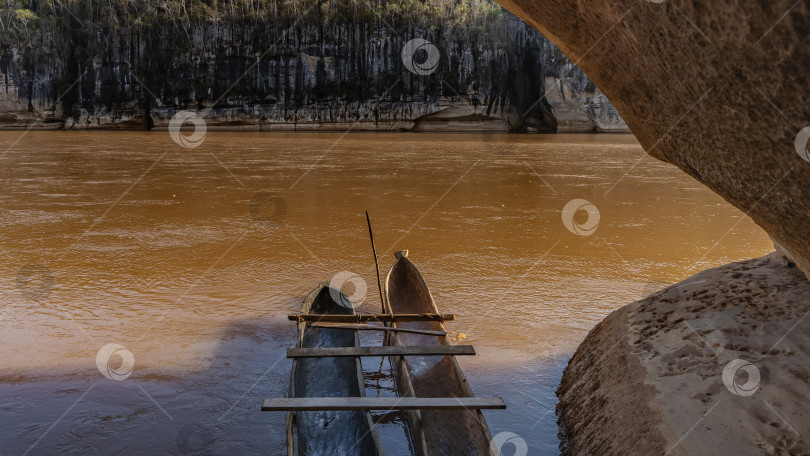 Скачать У обрыва пришвартованы деревянные самодельные каноэ с дощатыми сиденьями. фотосток Ozero
