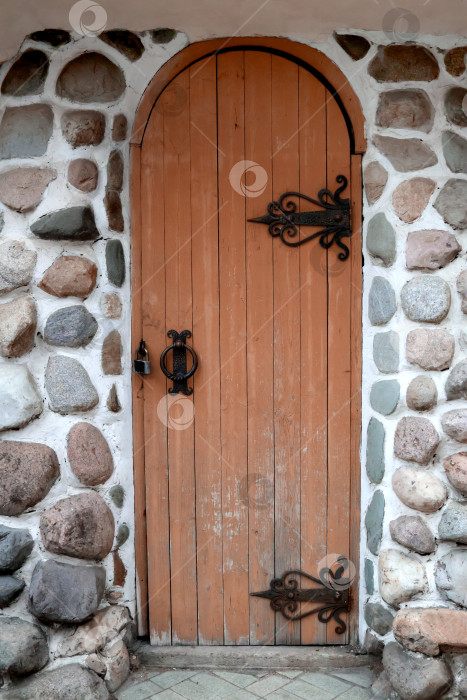 Скачать Старинная деревянная дверь со старинными резными петлями в каменной стене фотосток Ozero