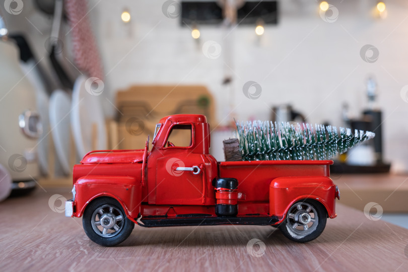 Скачать Красный ретро-автомобиль с рождественской елкой украшает праздничную кухню к Рождеству. Домашний декор, праздничное настроение, Новый год фотосток Ozero