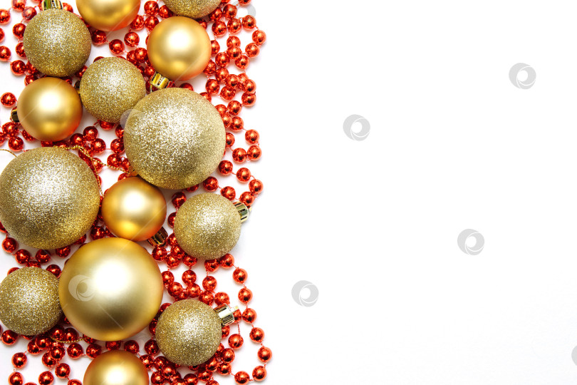 Скачать Золотые рождественские шары матовые и блестящие разных размеров с красными бусинами, гирляндами на белом изолированном фоне фотосток Ozero