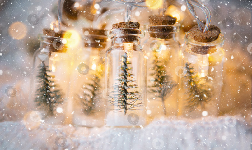 Скачать Волшебные огоньки в банке с рождественской елкой и снегом крупным планом создают теплое уютное настроение с золотой гирляндой. Рождество и Новый год, праздничный декор, копировальное пространство. Рождественский фон фотосток Ozero