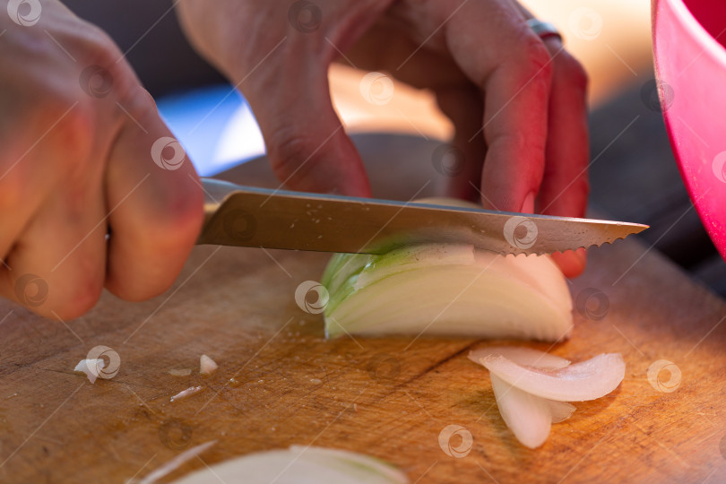 Скачать Нарезка лука полукольцами, крупным планом, на открытом воздухе, приготовление в кемпинге фотосток Ozero