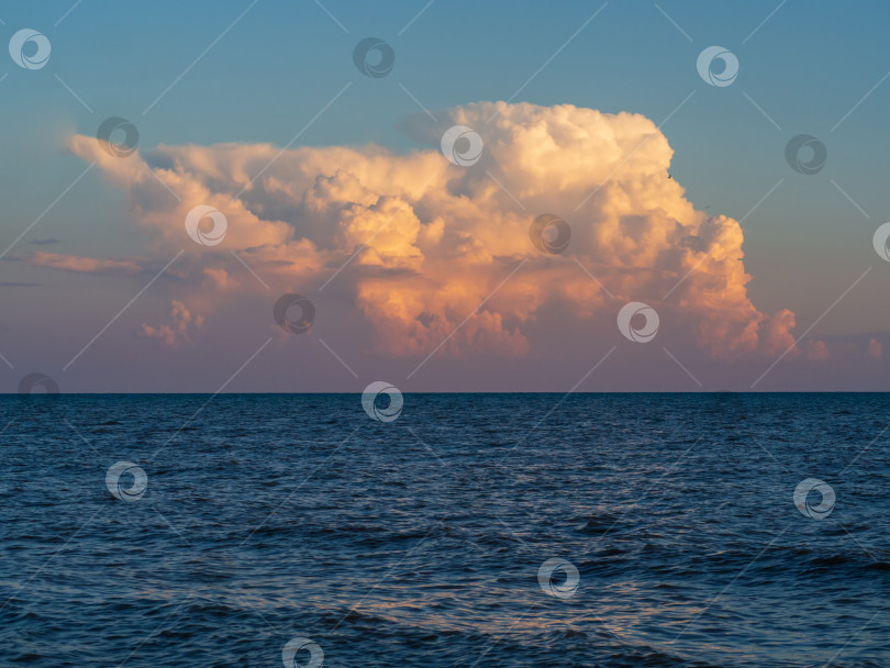 Скачать Большое облако над синей морской водой с волнами. Красивый облачный пейзаж над морем на закате фотосток Ozero