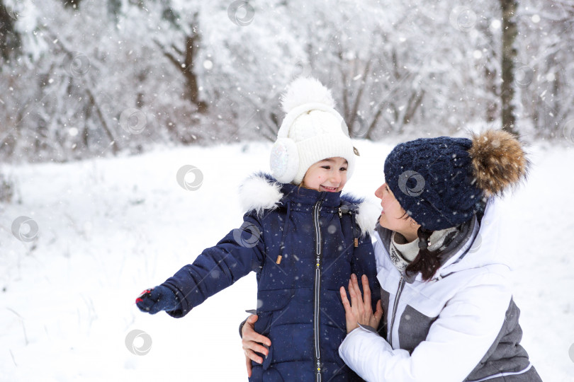 Скачать Мама и дочь обнимаются, с любовью глядя друг на друга, на прогулке. Зимние развлечения на улице, активный отдых, веселье в холода в теплой одежде. Отдых на свежем воздухе, веселое детство, крепкая семья фотосток Ozero