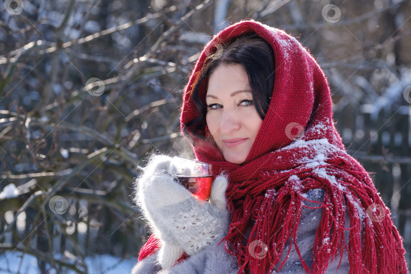 Скачать взрослая женщина в шубе и платке пьет чай на природе зимой фотосток Ozero