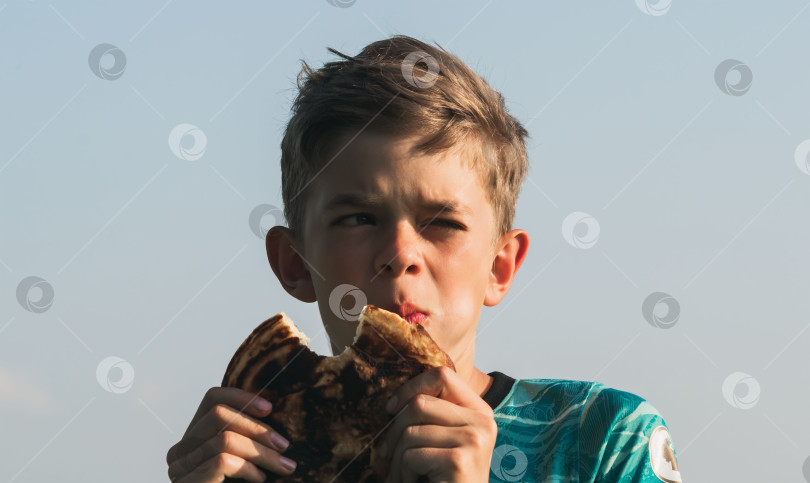 Скачать Маленький мальчик ест большой блин фотосток Ozero