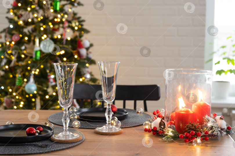 Скачать Праздничный стол, накрытый в гостиной на Рождество и Новый год в стиле лофт. Рождественская елка, черные тарелки и вилки, тканые салфетки, модная посуда, уютный интерьер дома фотосток Ozero