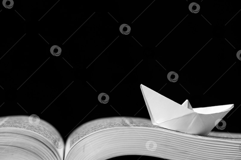 Скачать Бумажный кораблик на раскрытой книге фотосток Ozero