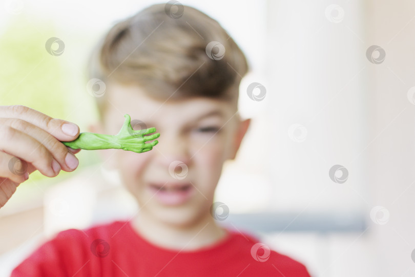 Скачать Маленький мальчик показывает поделку из пластилина фотосток Ozero