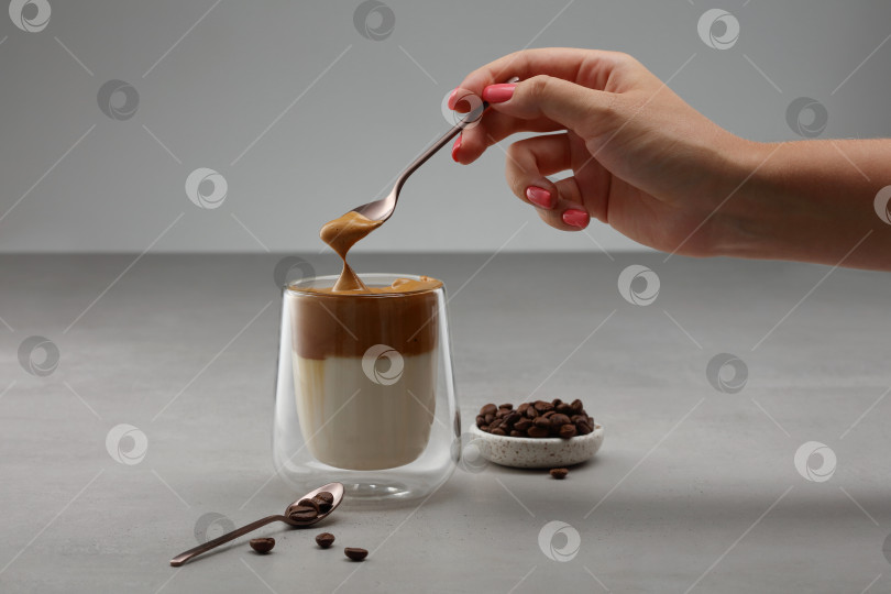 Скачать Чашка с кофе "Далгона" с ложечкой в женской руке. фотосток Ozero