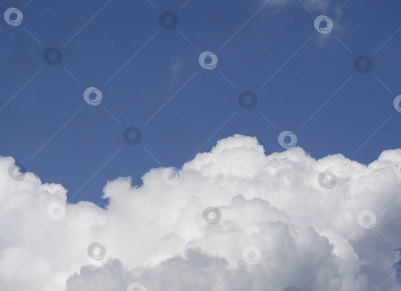 Скачать Огромное белое облако с тенями на ясном темно-синем небе. Воздушный естественный фон. Освободите место для текста. фотосток Ozero