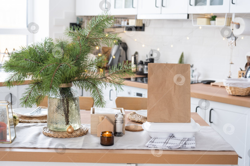 Скачать Контейнеры службы доставки еды на столе в белой кухне, празднично сервированные для празднования Рождества и нового года.  Экономия времени, горячий заказ, одноразовая пластиковая коробка, крафтовая упаковка. макет фотосток Ozero
