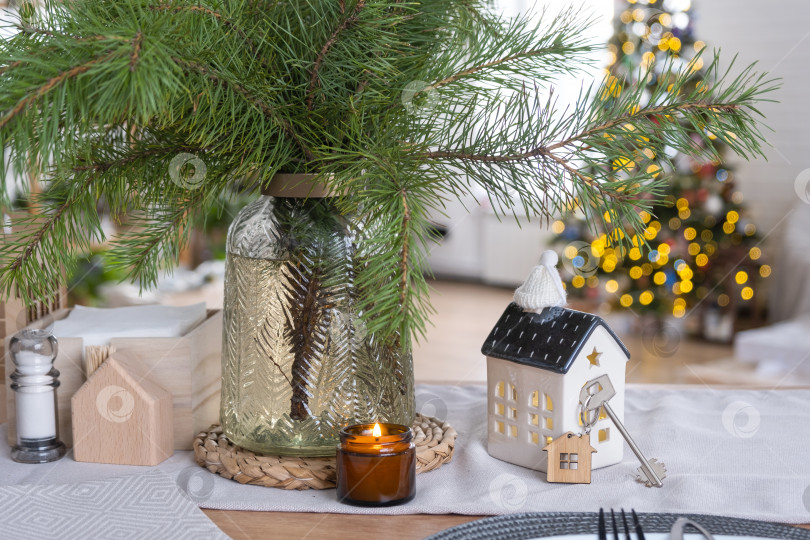 Скачать Ключ от дома в уютном доме с рождественским декором на столе праздничной кухни. Подарок на Новый год. Строительство, дизайн, проект, переезд в новый дом, ипотека, аренда и покупка недвижимости фотосток Ozero