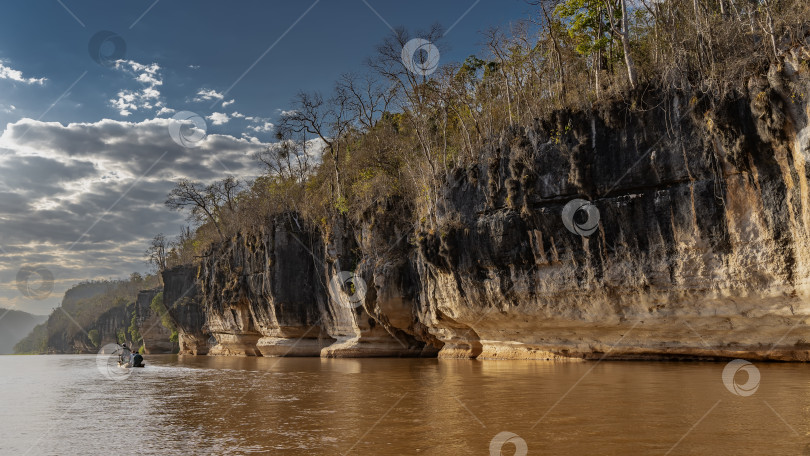 Скачать Каноэ с туристами плывет по реке с красно-оранжевой водой. фотосток Ozero