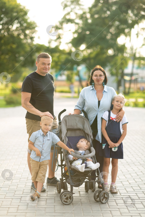 Скачать Семья с тремя детьми прогуливается по парку фотосток Ozero